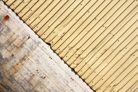 Grungy background texture - old stained concrete wall and yellow steel corrugated tinの写真素材