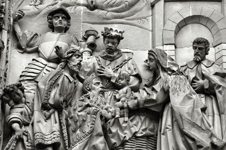 Three wise men or three kings visit the newborn Jesus Christ. They bear gifts of gold, frankincense, and myrrh. Sculpture above the Puerta del Nacimiento of Salamanca Cathedral.の写真素材