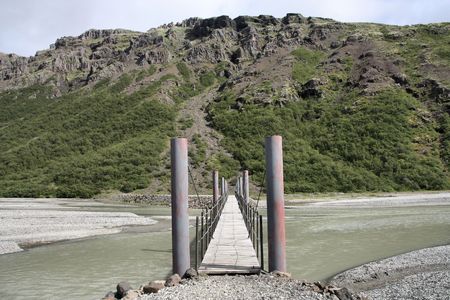 Footbridge over river Skeidara in Skaftafell National Park of Iceland. Hiking trail in the mountains.の写真素材