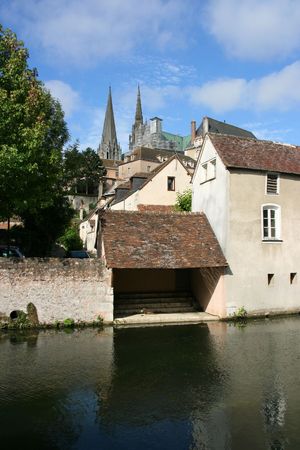 Chartres - Medieval town in France. Old buildings, water canal and Cathedral in background.