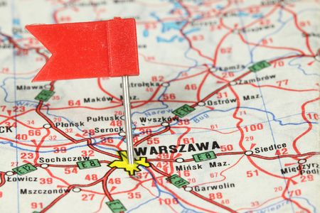 Warsaw (Warszawa) - capital city in Poland. Red flag pin on an old map showing travel destination.