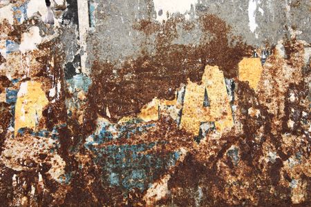 Old, rusty metal wall with remains of old posters and advertisements. Torn paper texture background.の写真素材