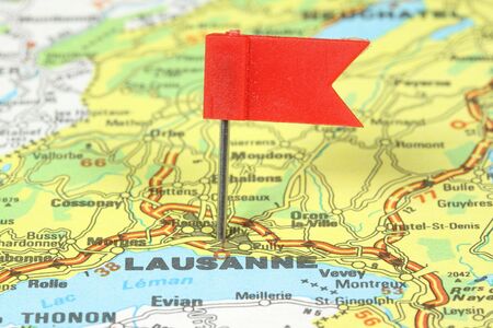 Lausanne - famous city in Switzerland. Red flag pin on an old map showing travel destination.の写真素材
