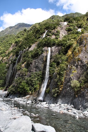 Westland National Park, New Zealand. Beautiful small waterfalls near Franz Josef Glacier. Temperate rainforest bush.の写真素材