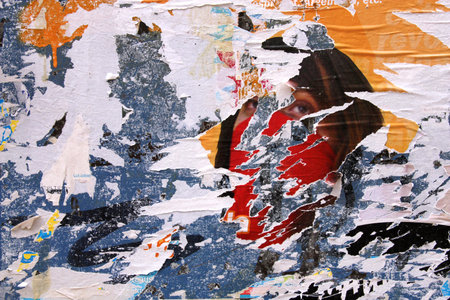 Stripped posters on old wall, vandalism and urban decay