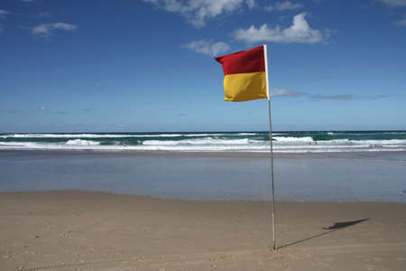 Sandy beach with safety flag in Surfers Paradise city, Gold Coast region of Queensland (Australia)