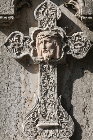 Milan, Italy. Old grave ornamental cross with Jesus Christ at the Monumental Cemetery (Cimitero Monumentale). Religious art.の写真素材