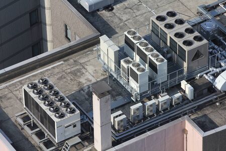 Exhaust vents of industrial air conditioning and ventilation units. Skyscraper roof top in Tokyo, Japan.の写真素材