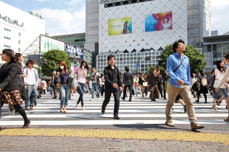 TOKYO - MAY 11: Commuters hurry on May 11, 2012 in Shibuya, Tokyo. Shibuya crossing is one of busiest places in Tokyo and is recognized thanks to being featured in multiple films.のeditorial素材