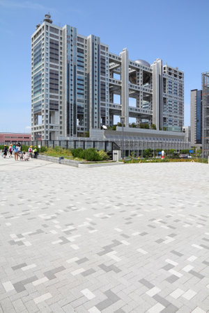 TOKYO - MAY 11: People walk by Fuji TV building on May 11, 2012 in Tokyo. Fuji TV Studios building at Odaiba island was designed by famous Kenzo Tange and is one of most recognized buildings in Japan.のeditorial素材
