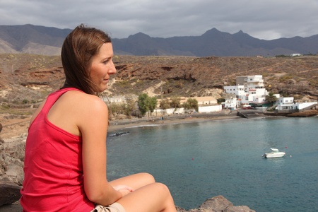 Pretty young adult traveler visits Tenerife, Canary Islands, Spain - town of El Puertito.