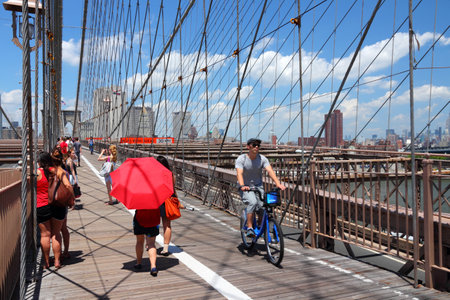 NEW YORK - JULY 5: People walk and cycle along famous Brooklyn Bridge on July 5, 2013 in New York. Almost 19 million people live in New York City metropolitan area.のeditorial素材