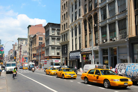 NEW YORK - JULY 4: People ride taxi cabs along West Broadway on July 4, 2013 in Tribeca district,...