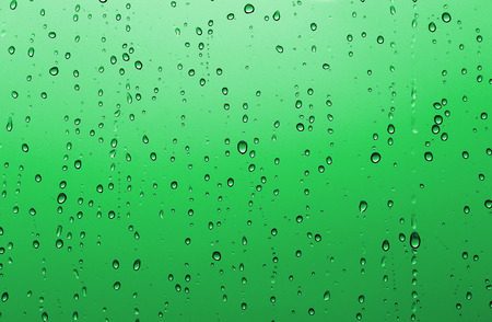 Blue water drop background. Raindrops on window glass.の写真素材