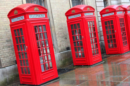 London, United Kingdom - red telephone boxes in wet rainy weather. View of Broad Court, Covent...