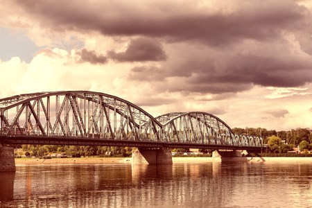 Poland - Torun famous truss bridge over Vistula river. Transportation infrastructure. Cross processed color tone - retro filtered style.の写真素材