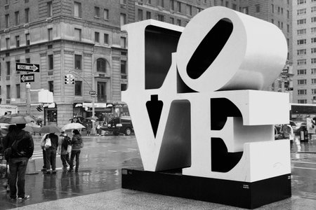 NEW YORK, USA - JUNE 7, 2013: People walk past Love sculpture in rain in New York City. The famous monument by Robert Indiana is located on 6th Avenue.のeditorial素材