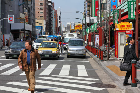 TOKYO, JAPAN - APRIL 13, 2012: Man crosses street in Asakusa district, Tokyo. Asakusa is one of the oldest districts of Tokyo, capital city and largest urban area of Japan (35 million people in metro area).のeditorial素材