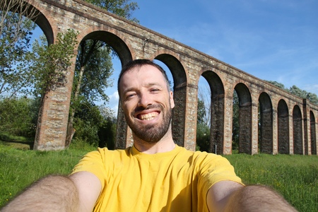 Tourist selfie in Italy - old Roman aqueduct in Lucca, Tuscany.の写真素材