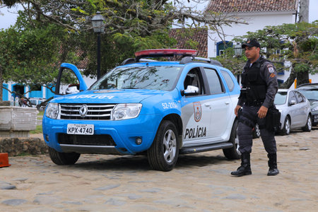 PARATY, BRAZIL - OCTOBER 14, 2014: Police officer walks next to Renault Duster police car in Paraty...