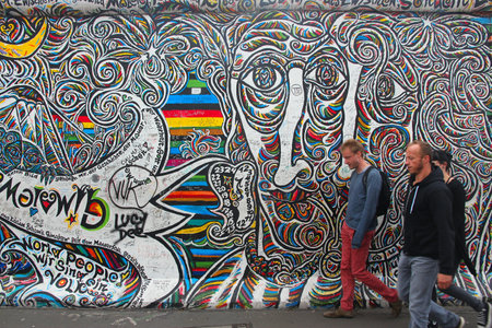 BERLIN, GERMANY - AUGUST 26, 2014: People visit urban art of East Side Gallery at public street in Berlin. Part of former Berlin Wall is covered in art by more than 100 artists since 1990.のeditorial素材