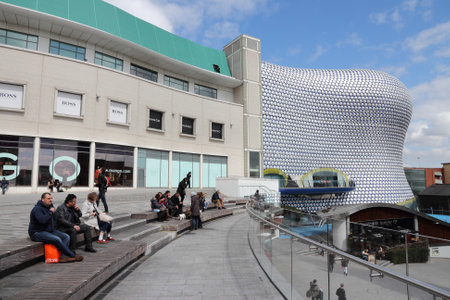 BIRMINGHAM, UK - APRIL 19, 2013: People sit next to Selfridges department store in Birmingham. The modern building is part of Bullring Shopping Centre and was completed in 2003.のeditorial素材