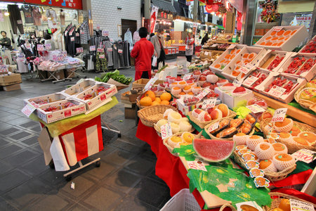 OSAKA, JAPAN - APRIL 25, 2012: Shoppers visit Nipponbashi Kuromon market in Osaka, Japan. According to Tripadvisor, it is currently among best 3 shopping places in Osaka.のeditorial素材