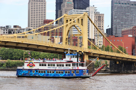 PITTSBURGH, USA - JUNE 30, 2013: People ride a river cruise under a bridge in Pittsburgh city. It is the 2nd largest city of Pennsylvania with population of 305,841.のeditorial素材