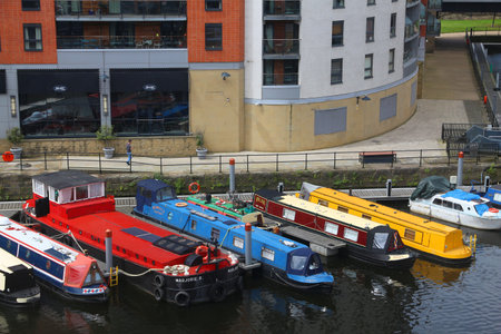 LEEDS, UK - JULY 12, 2016: Man walks by houseboats moored in Leeds, UK. There are 15,000 people living in house boats in the UK.のeditorial素材