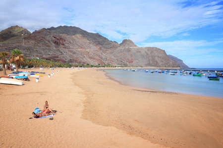 TENERIFE, SPAIN - OCTOBER 27, 2012: Tourists visit Teresitas Beach in Tenerife. Spain is the 3rd most visited country in the world with 75 million annual tourists (2016).のeditorial素材