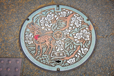 NARA, JAPAN - NOVEMBER 23, 2016: Manhole cover in Nara. Japan frequently has beautiful decorative sewer covers.のeditorial素材