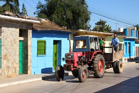 TRINIDAD, CUBA - FEBRUARY 5, 2011: People ride a tractor in the Old Town in Trinidad, Cuba. The Old Town is UNESCO World Heritage Site and is one of most recognized places in Cuba.のeditorial素材