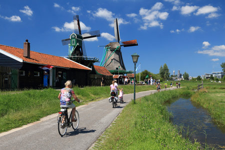 ZAANSE SCHANS, NETHERLANDS - JULY 9, 2017: Cyclists visit windmills of Zaanse Schans. Netherlands has 35,000 km of cycleways physically separated from motor traffic.のeditorial素材