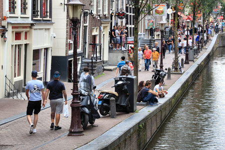 AMSTERDAM, NETHERLANDS - JULY 8, 2017: People visit Red Light District in Amsterdam, Netherlands. Amsterdam is notable for its relaxed laws towards prostitution.のeditorial素材