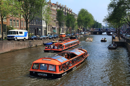 AMSTERDAM, NETHERLANDS - JULY 7, 2017: People ride tour boats at Prinsengracht canal in Amsterdam, Netherlands. Amsterdam is the capital city of The Netherlands.のeditorial素材
