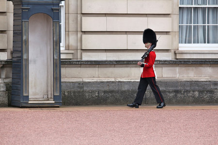 LONDON, UK - APRIL 23, 2016: Queen's Guard soldier stands in front of Buckingham Palace in London, UK. The guards in traditional uniforms are important symbol of the UK.のeditorial素材