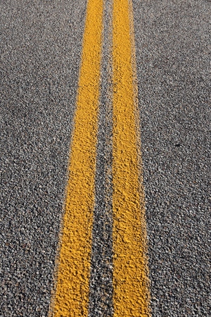 Asphalt concrete roadway pavement surface. Grey background with yellow line.の写真素材