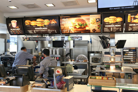 AMSTERDAM, NETHERLANDS - JULY 8, 2017: Employees work the kitchen of McDonald's restaurant in Amsterdam. McDonald's is the world's largest restaurant chain with 69 million customers served daily.のeditorial素材