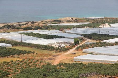 Greenhouse farming landscape of Crete island in Greece. Agriculture along the coast - olive groves and fruit greenhouses.の写真素材