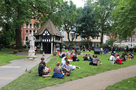 LONDON, UK - JULY 9, 2016: People visit the park at Soho Square in London, UK. London is the most populous city in the UK with 13 million people living in its metro area.のeditorial素材