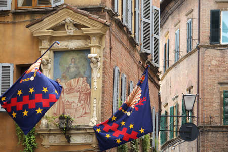 Siena, Italy. Old Town is divided into traditional districts (contrade) with distinct flags and colors. Contrada Nicchio (Seashell).の写真素材