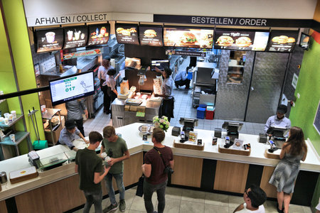 AMSTERDAM, NETHERLANDS - JULY 10, 2017: Employees work the kitchen of McDonald's restaurant in...