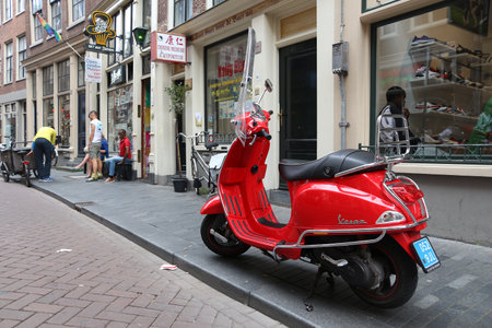 AMSTERDAM, NETHERLANDS - JULY 8, 2017: Red Piaggio Vespa scooter parked in Amsterdam, Netherlands. Vespa regained its popularity in recent years.のeditorial素材