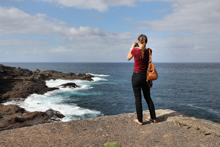 Tourist taking photos at Punta Sardina in Gran Canaria island, Spain.の写真素材