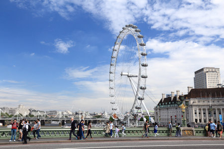 LONDON, UK - JULY 7, 2016: People walk by London Eye in London. The Eye is the tallest ferris wheel in Europe.のeditorial素材