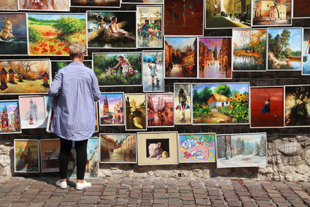 KRAKOW, POLAND - AUGUST 28, 2018: Artist sells paintings at St. Florian's Gate, Krakow. The Historic Centre of Krakow is a UNESCO World Heritage Site.のeditorial素材