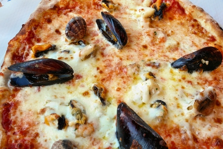 Frutti di mare pizza in Apulia, Italy. Pizza with clams, mussels and shrimps.の写真素材
