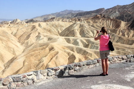 DEATH VALLEY, USA - APRIL 13, 2014: Tourist takes mobile photos of Zabriskie Point in Death Valley, California. Death Valley National Park was visited by 951 thousand people in 2013.のeditorial素材