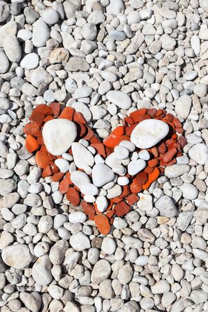 Red heart shape made of beach pebbles. Valentine's Day symbol.の写真素材