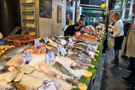 LONDON, UK - APRIL 22, 2016: Customer buys fish at Borough Market in Southwark, London. It is one of oldest markets in Europe. Its 1,000th birthday was in 2014.のeditorial素材